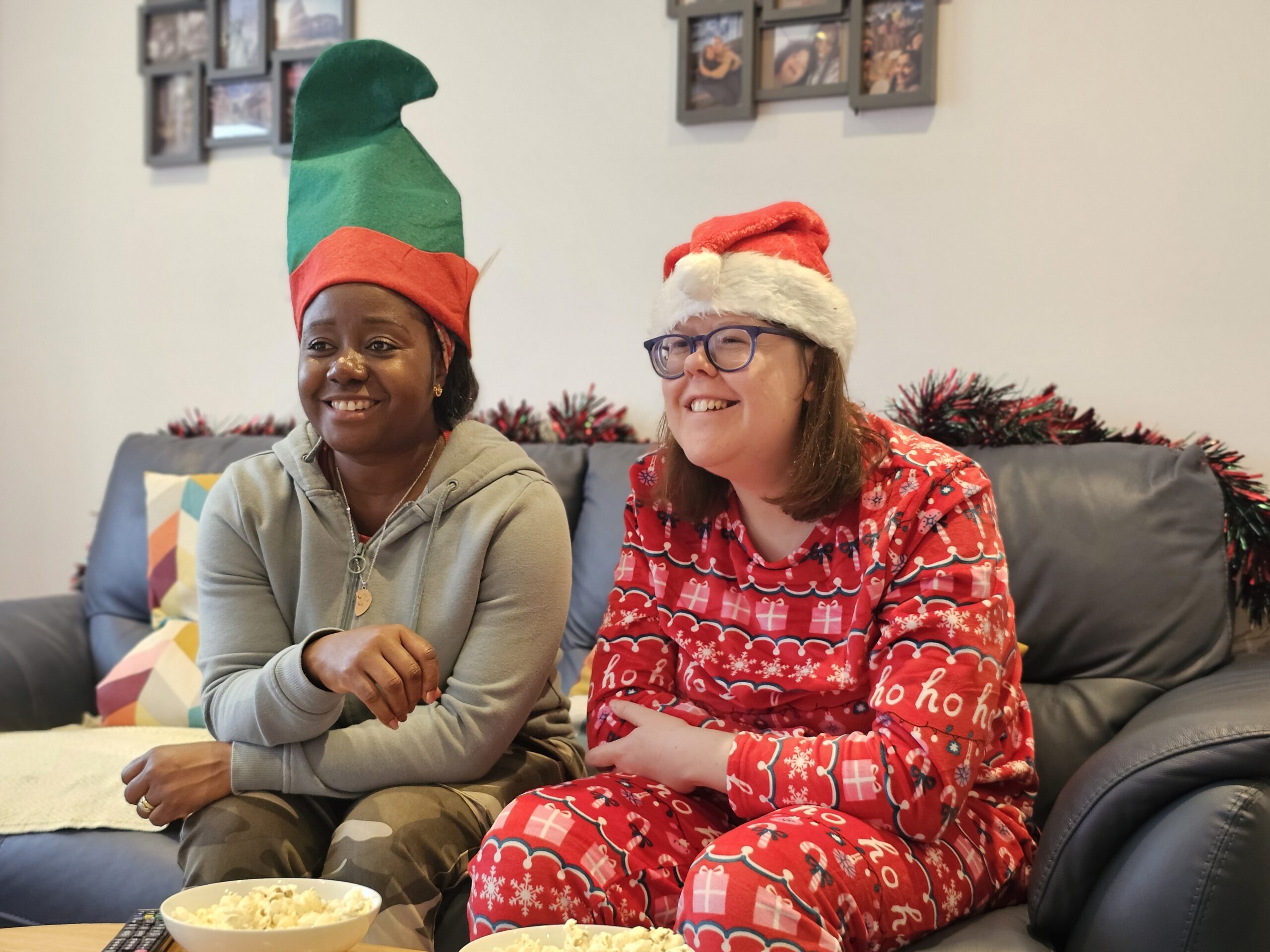 A woman wearing festive PJs sorting through fairy lights to prepare for her movie night.