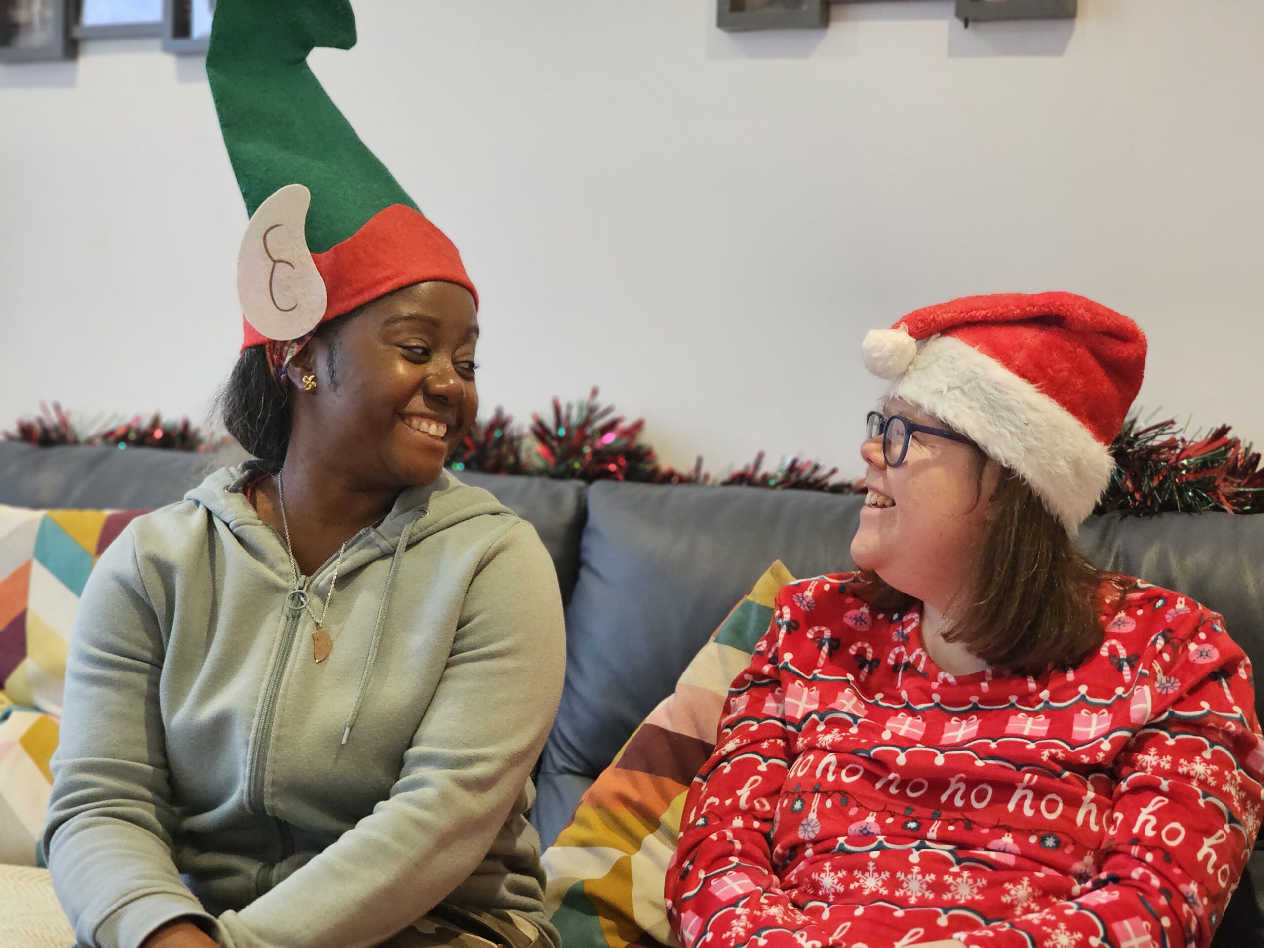 Two festively-dressed women exchanging smiles.