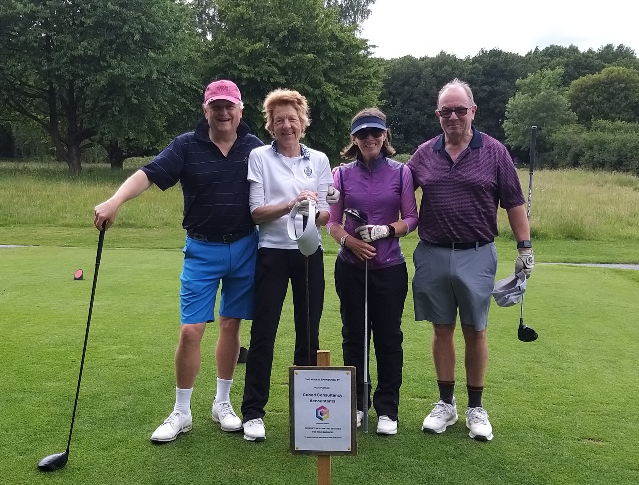 The team from Cubed Consultancy standing beside their hole sponsor sign.