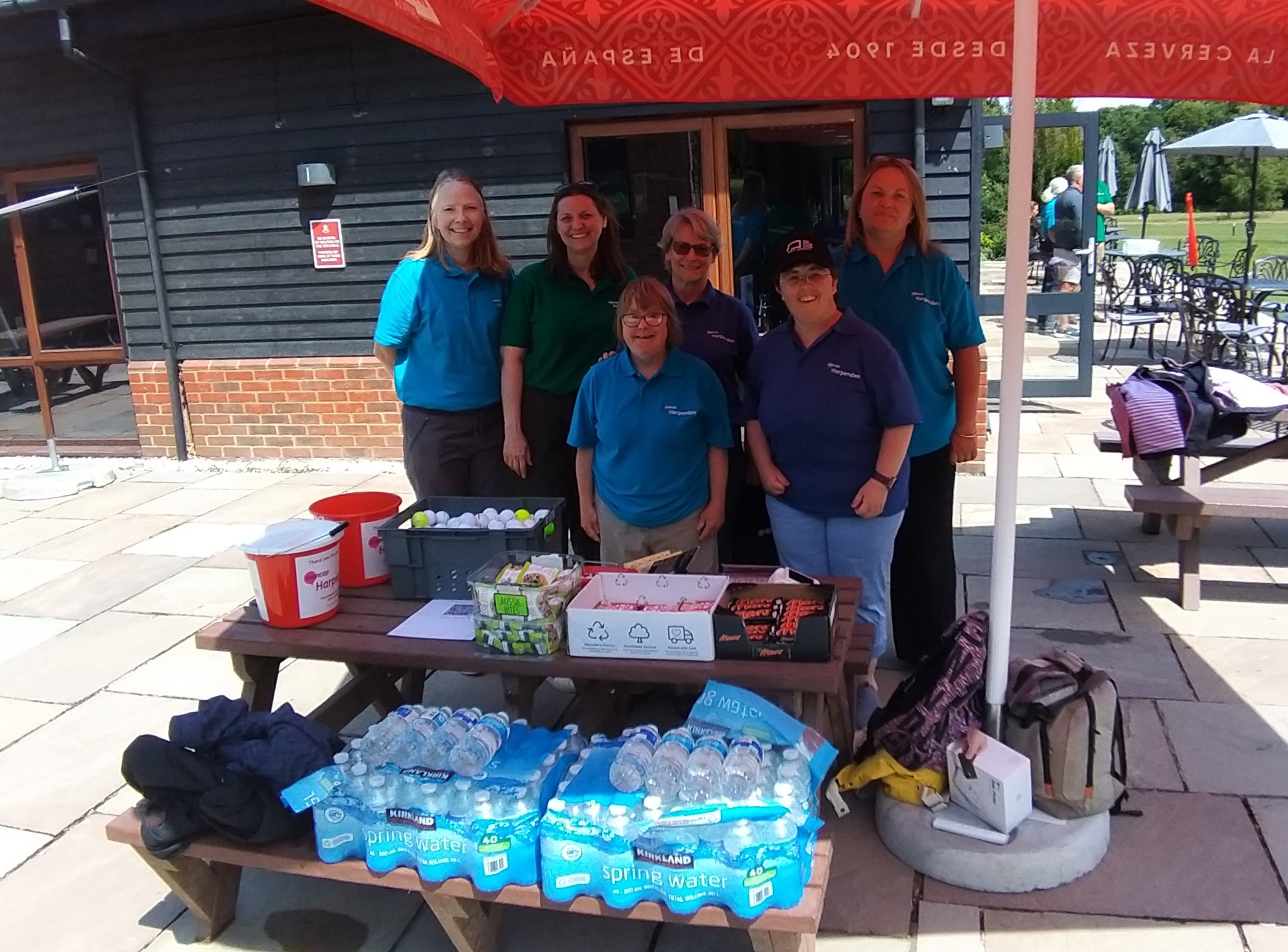 The team from Harpenden Mencap standing with supplies of bottles of water and snacks for players.