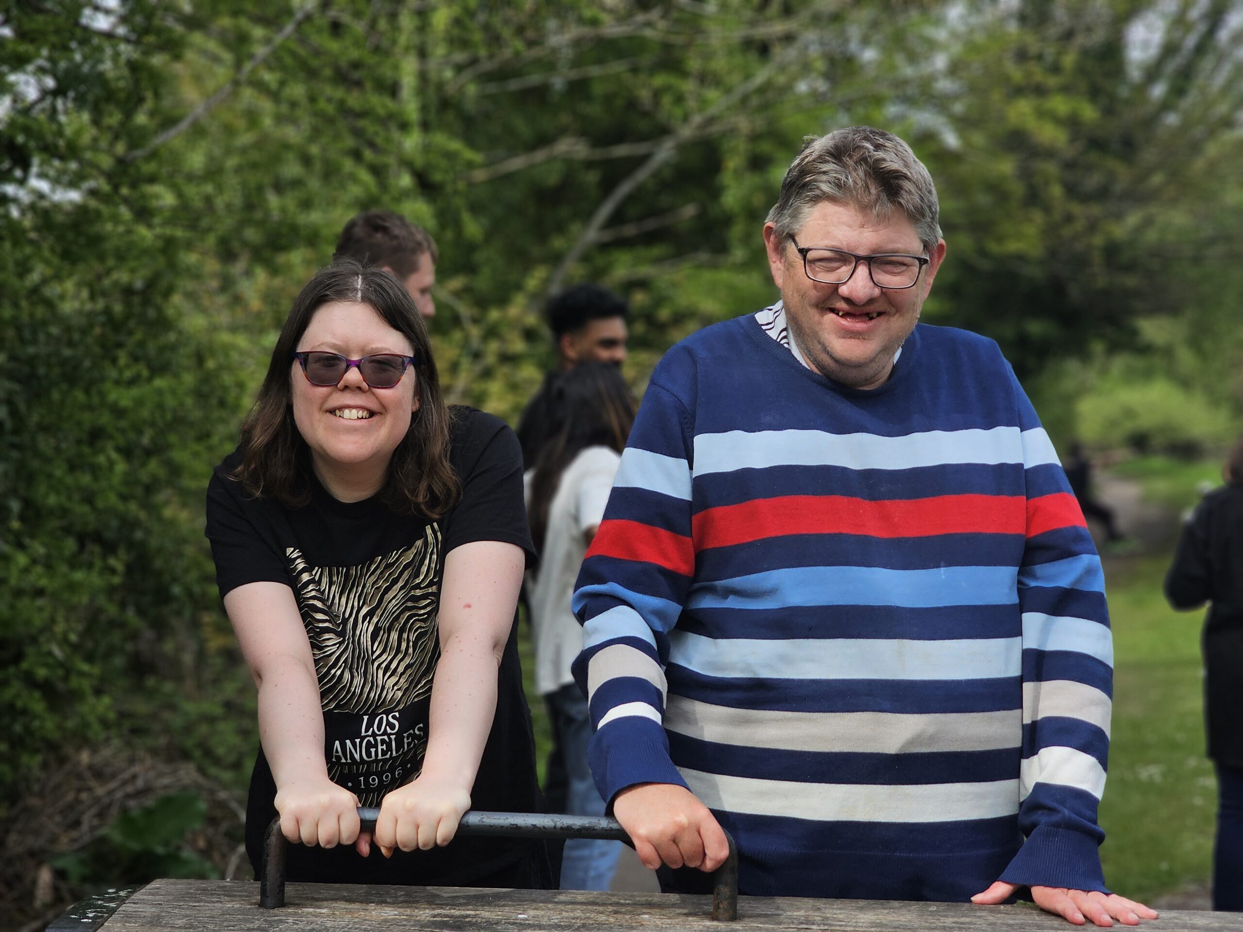 Adults with learning disabilities enjoying activities together and smiling at the camera.