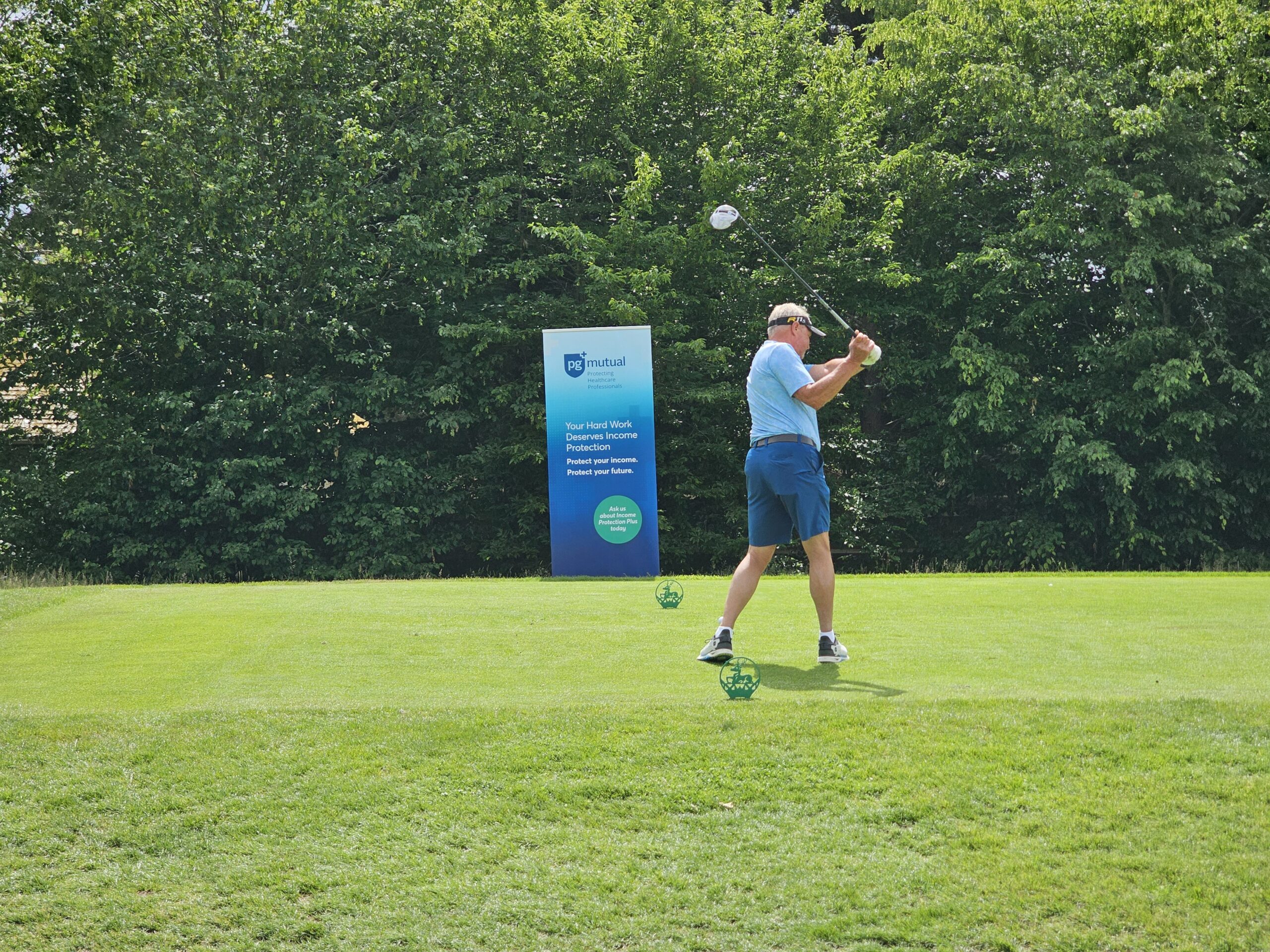 A player taking a swing before the PG Mutual banner