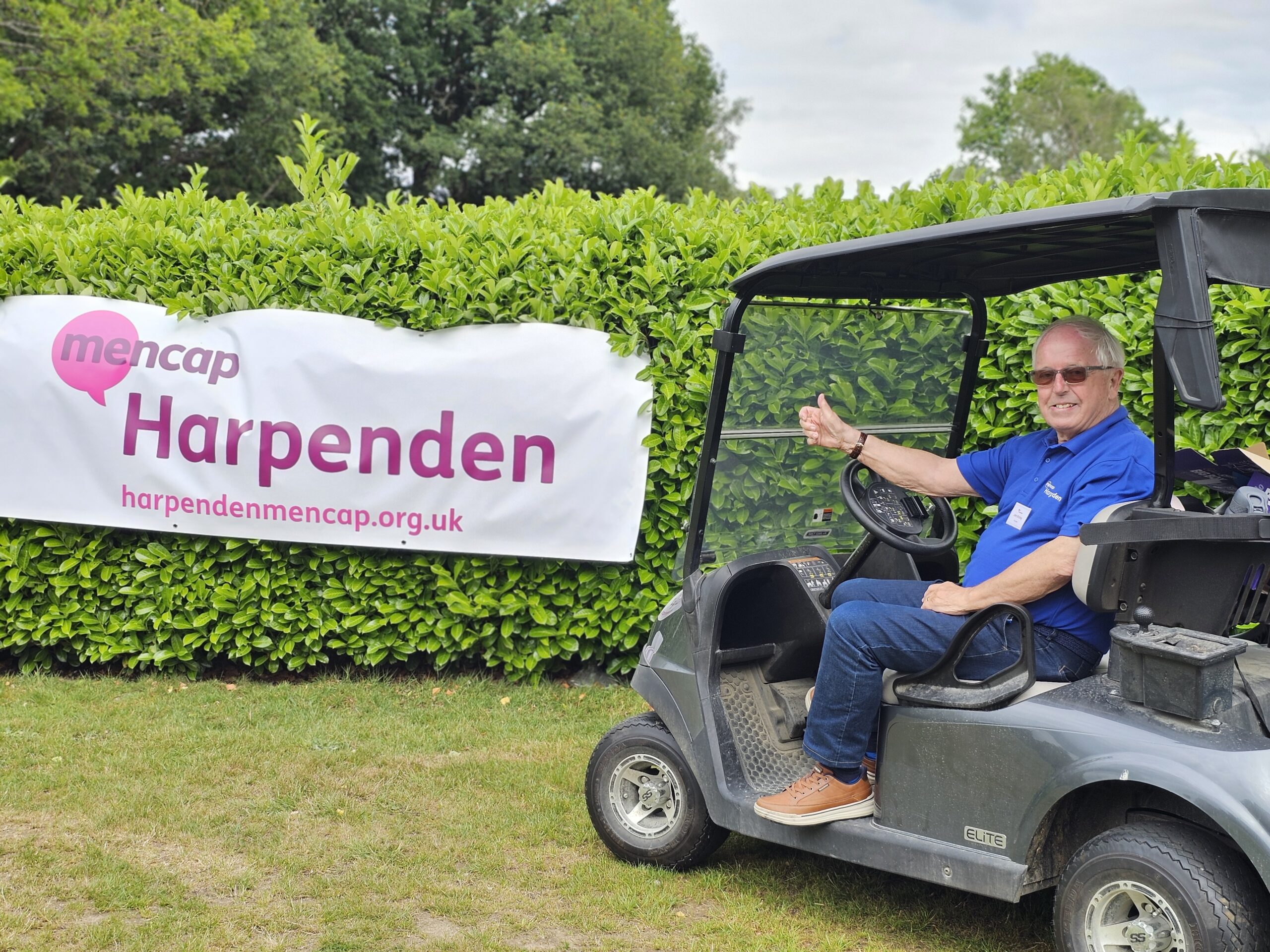 Volunteer in a buggy with Harpenden Mencap's new banner